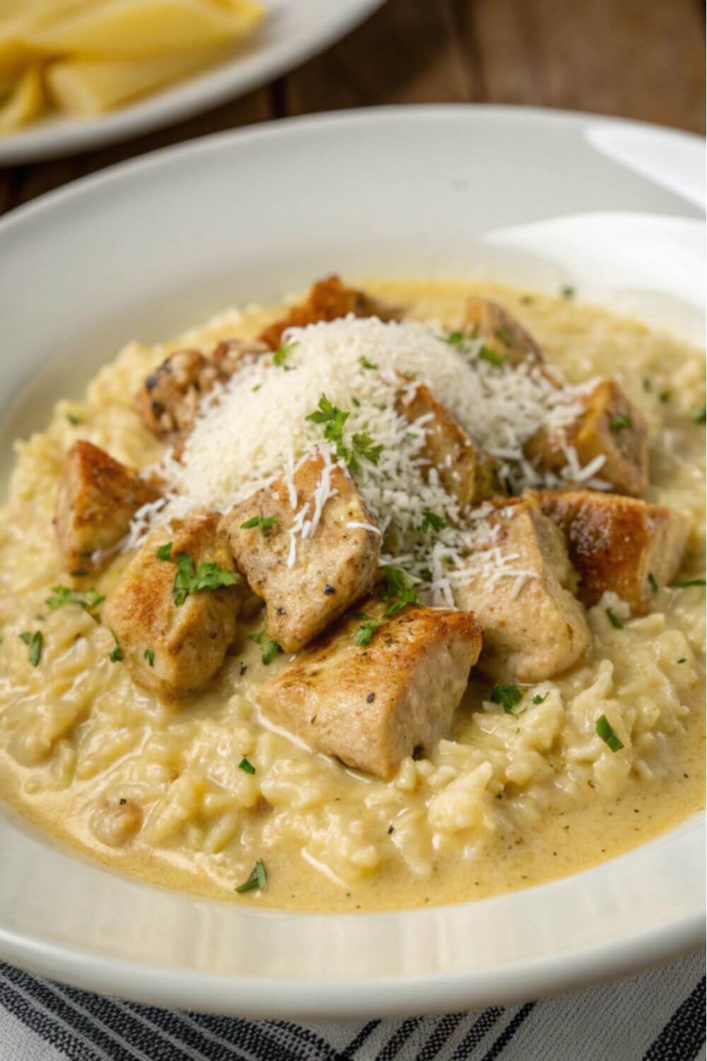 Chicken and rice in a parmesan sauce with grated parmesan on top.