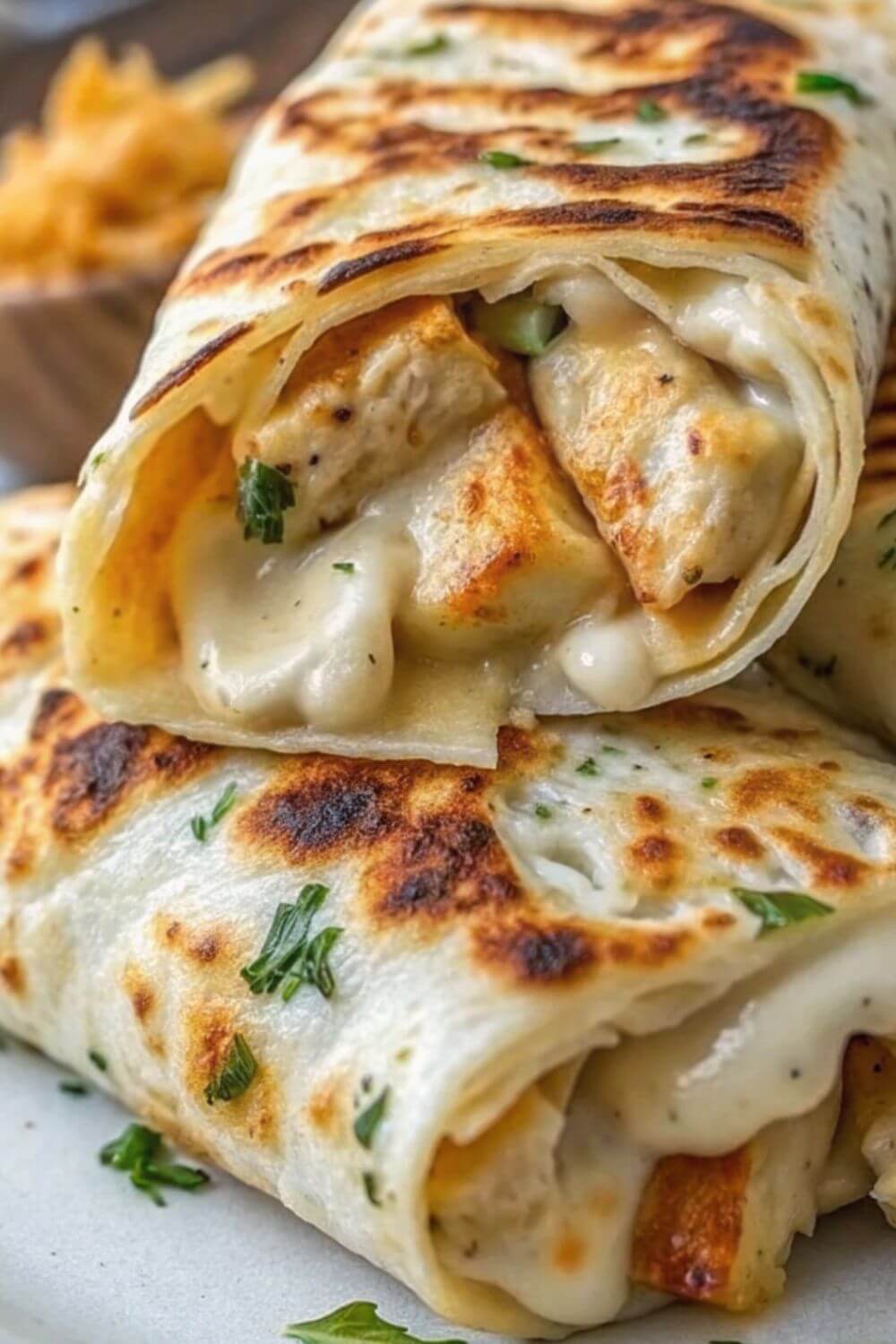 Chicken wraps dripping with cheese sauce.