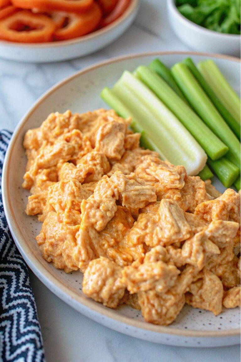 Chicken salad on a plate with celery sticks.