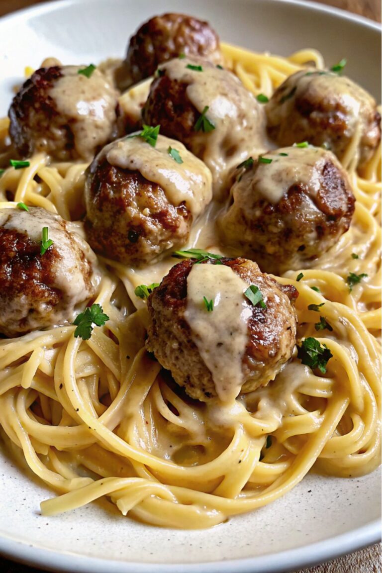 Meatballs served on pasta with sauce.